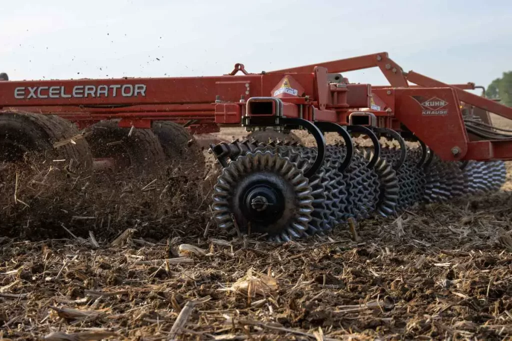 Close-up of a red 'Excelerator' tillage equipment by KUHN Krause working in the field, turning over soil after harvest
