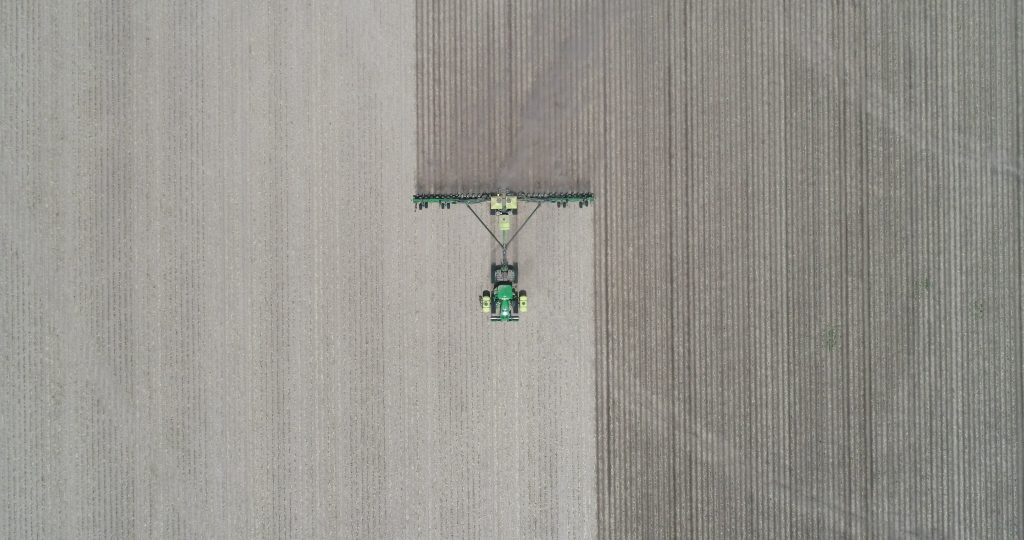 ploughing a field of crops - ariel view